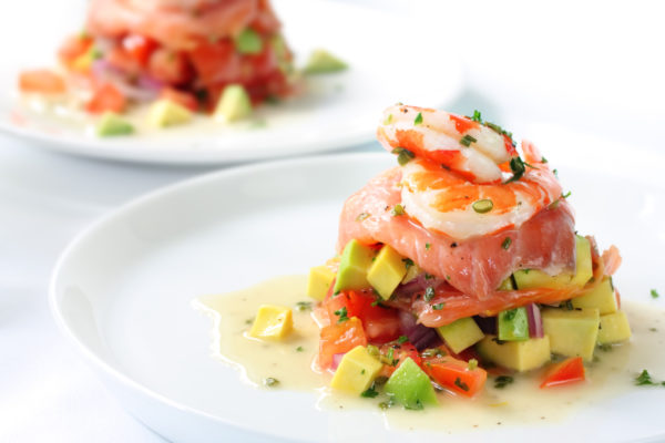 Smoked salmon with an avocado and tomato salsa, topped with king prawns.